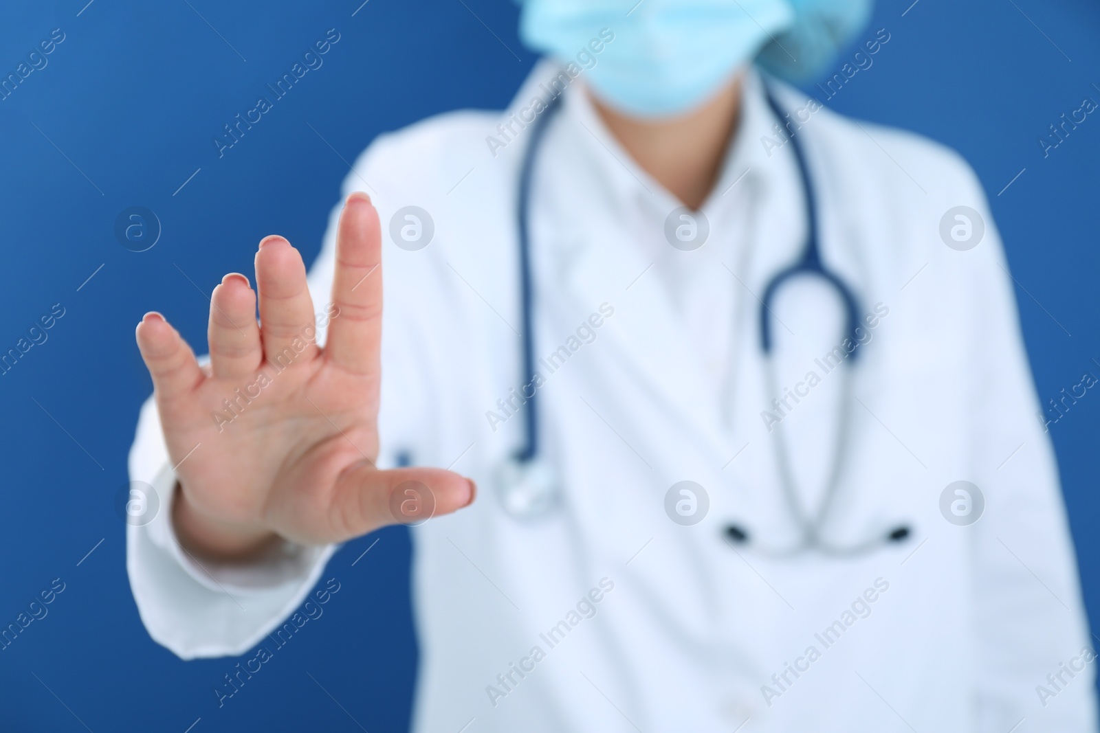 Photo of Doctor holding something on blue background, closeup. Space for text