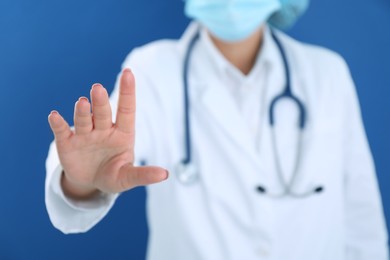 Photo of Doctor holding something on blue background, closeup. Space for text