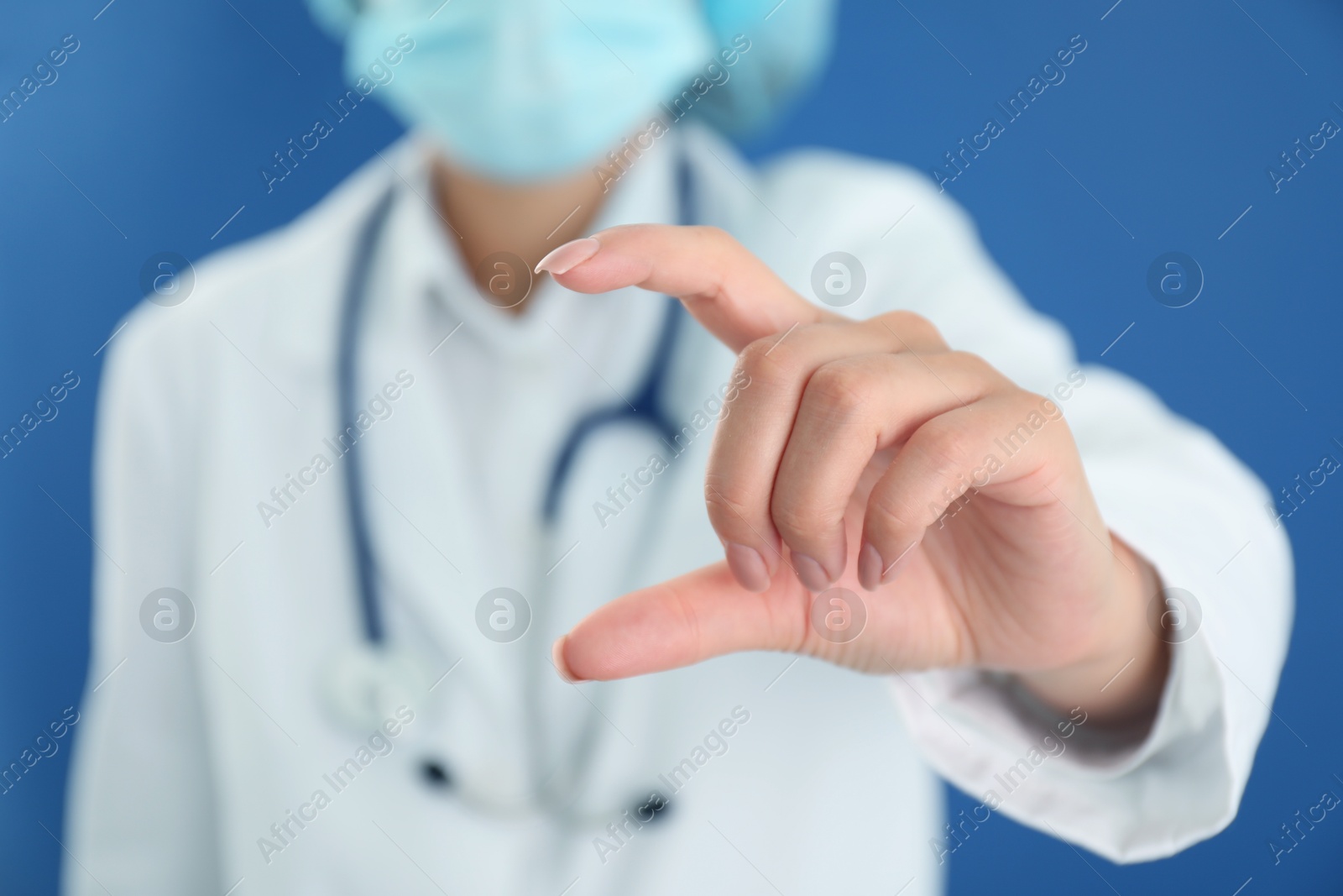 Photo of Doctor holding something on blue background, closeup