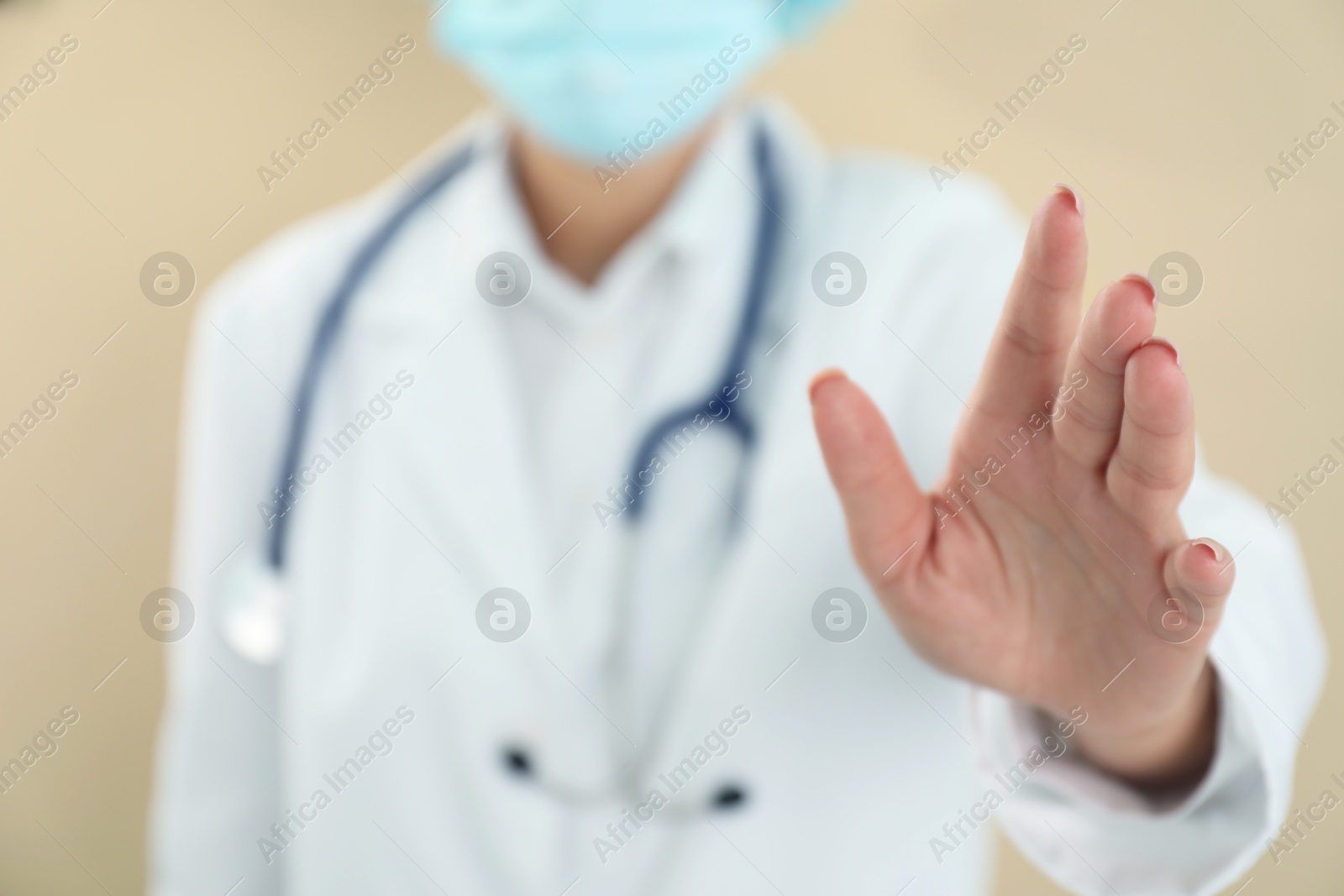 Photo of Doctor holding something on beige background, closeup