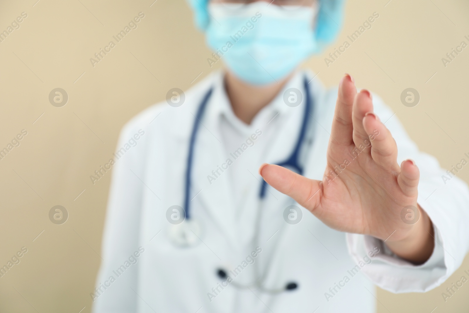 Photo of Doctor holding something on beige background, closeup