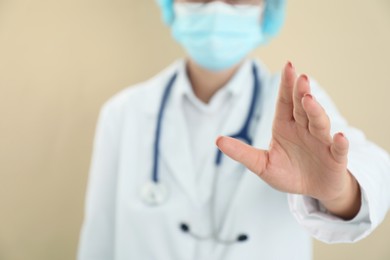 Photo of Doctor holding something on beige background, closeup