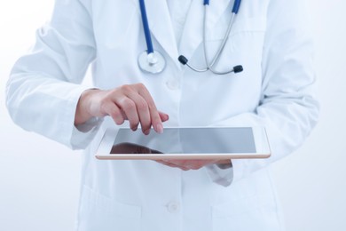 Doctor with tablet on white background, closeup view