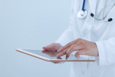 Photo of Doctor with tablet on white background, closeup view