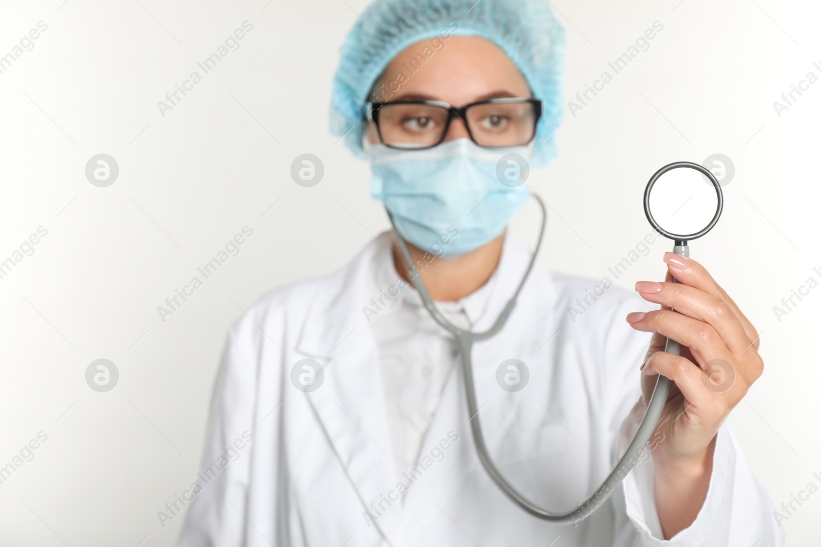 Photo of Doctor holding stethoscope on white background, selective focus