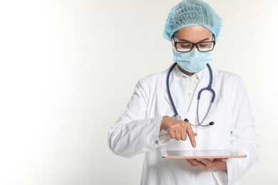 Photo of Doctor using tablet on white background, space for text