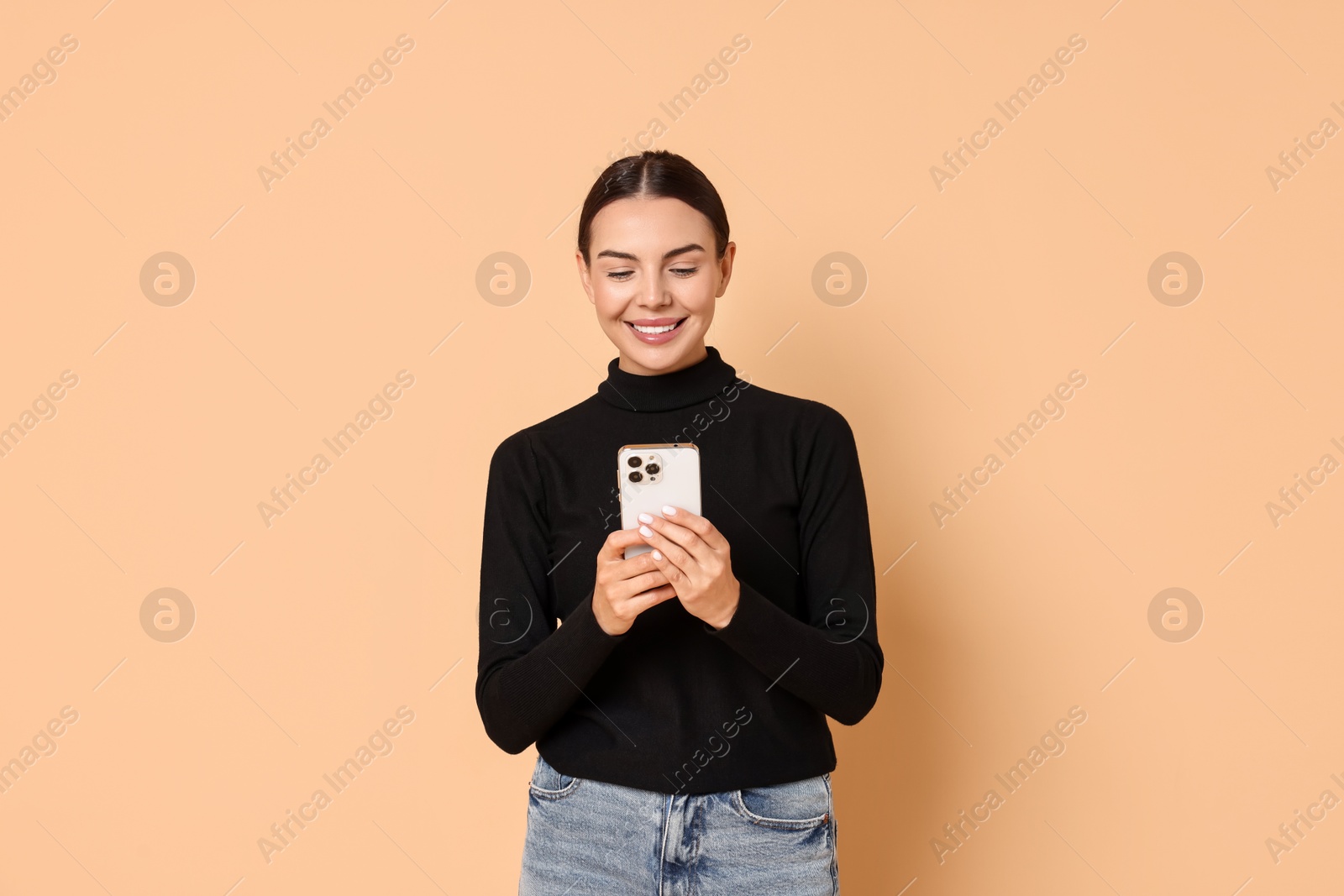 Photo of Smiling woman with smartphone on beige background