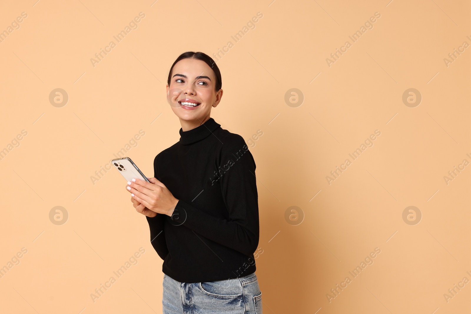 Photo of Smiling woman with smartphone on beige background. Space for text