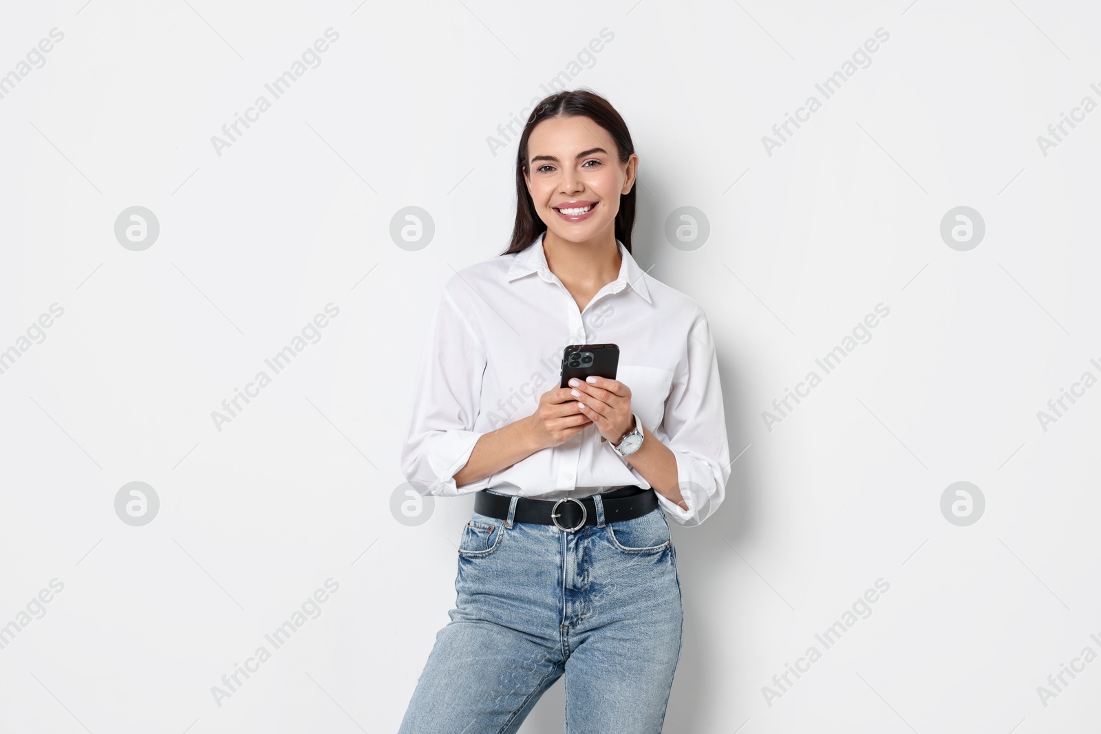 Photo of Smiling woman with smartphone on white background