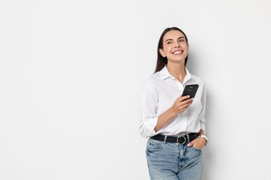 Photo of Smiling woman with smartphone on white background. Space for text