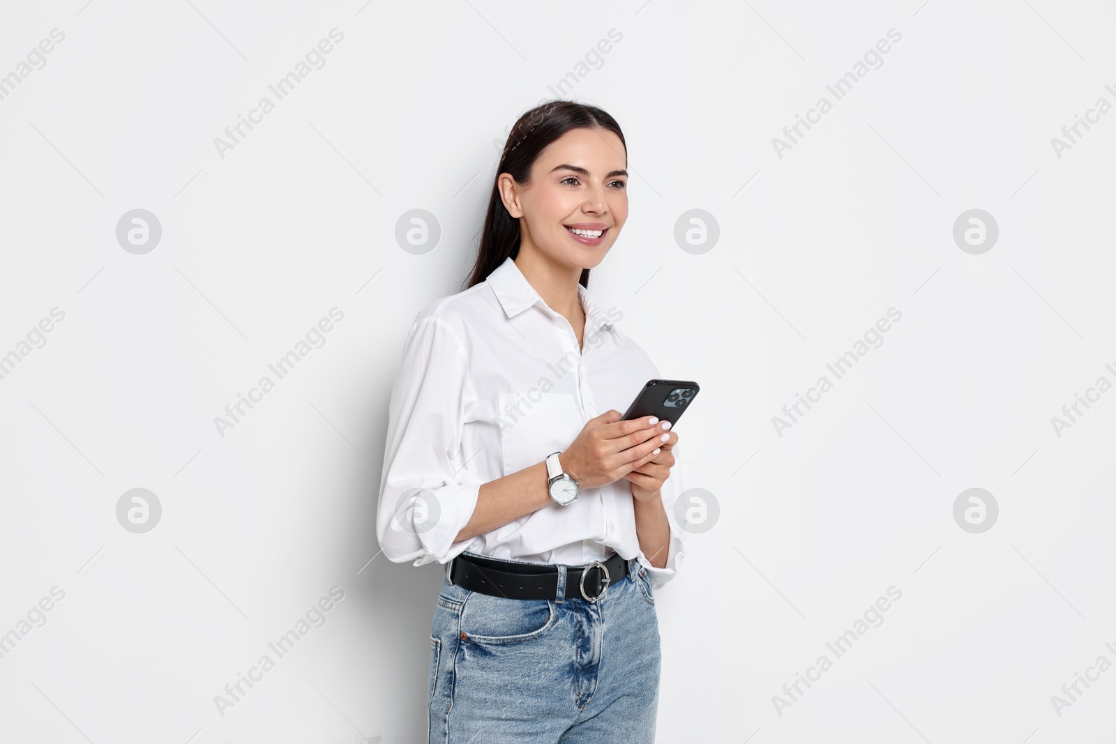 Photo of Smiling woman with smartphone on white background