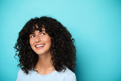 Happy young woman on light blue background, space for text. Dental veneers