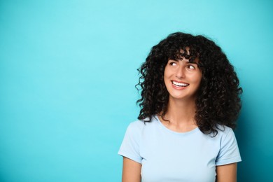 Happy young woman on light blue background, space for text. Dental veneers