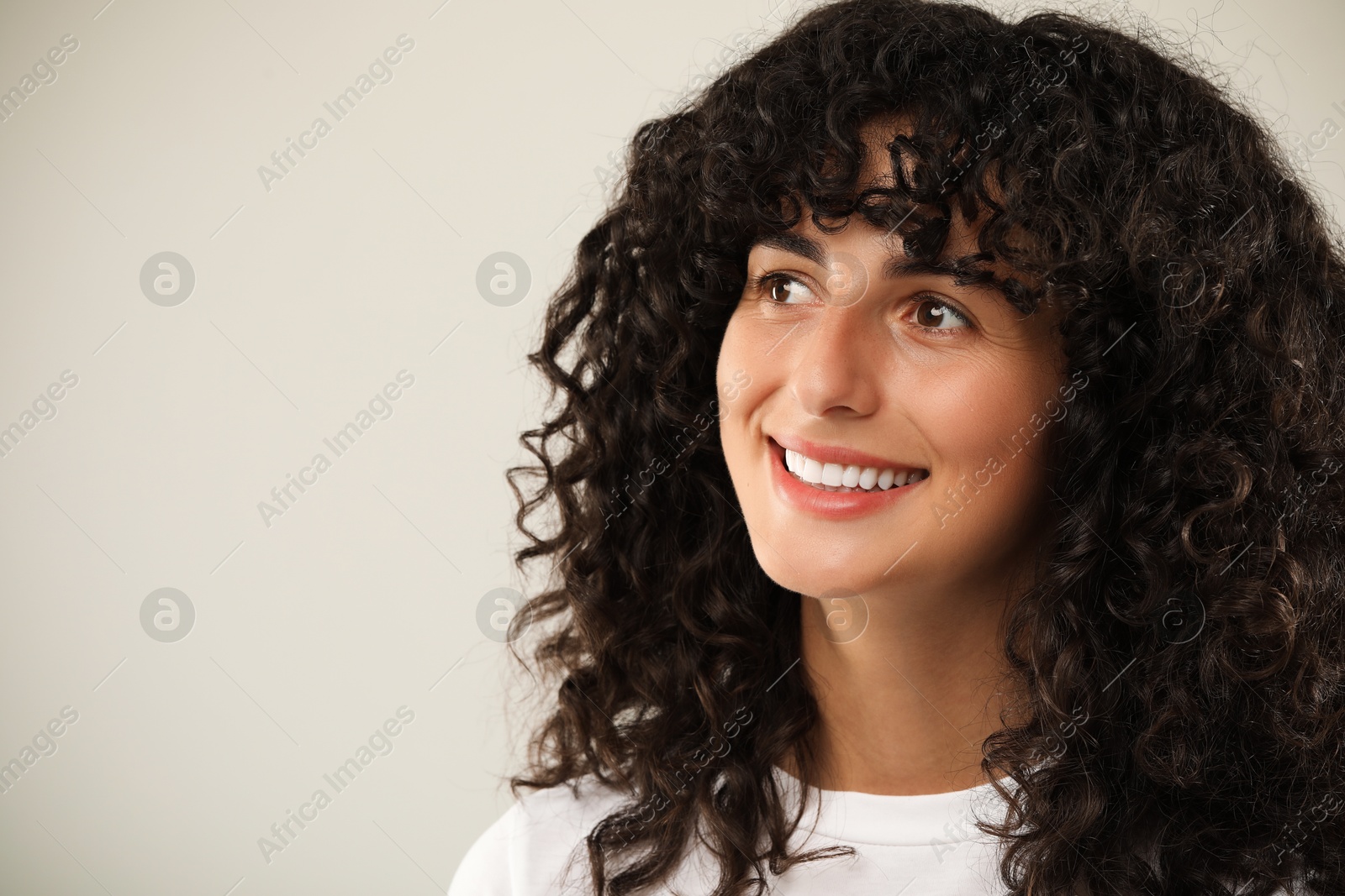 Photo of Happy young woman on light grey background, space for text. Dental veneers