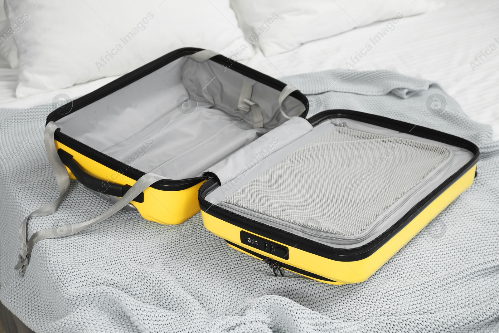 Photo of Open empty suitcase for travelling on bed indoors