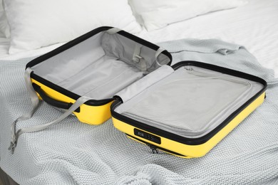 Photo of Open empty suitcase for travelling on bed indoors