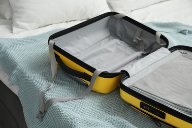 Photo of Open empty suitcase for travelling on bed indoors, closeup