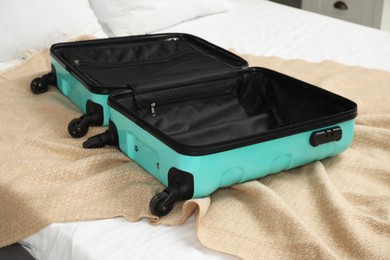 Open empty suitcase for travelling on bed indoors