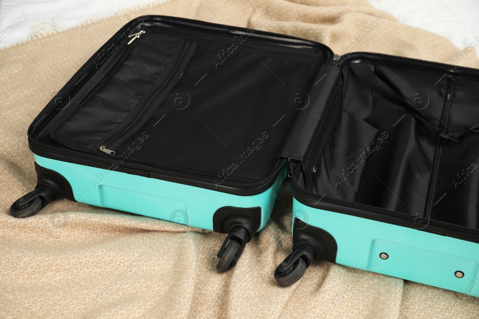 Photo of Open empty suitcase for travelling on bed indoors, closeup