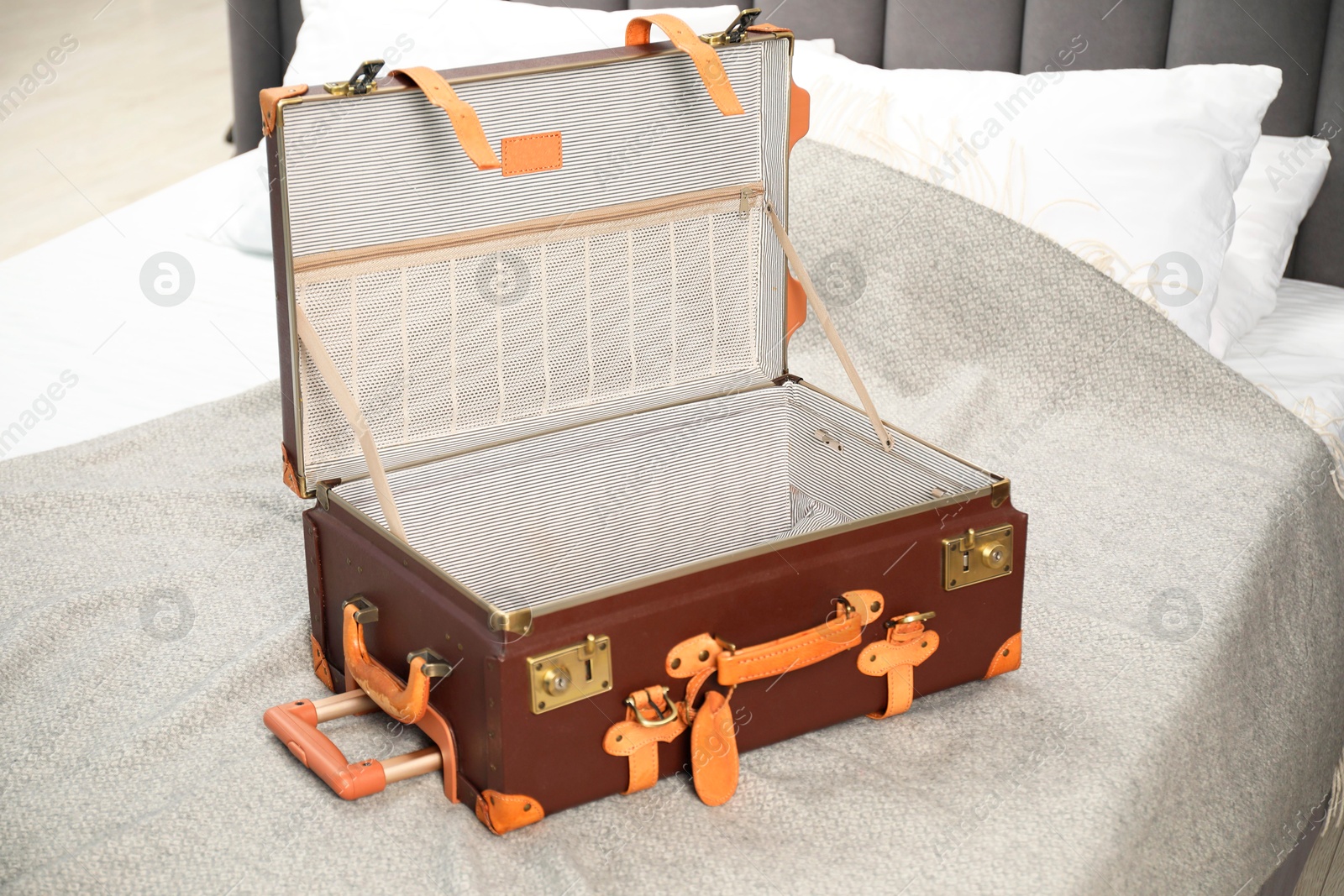 Photo of Open empty suitcase for travelling on bed indoors