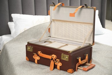 Photo of Open empty suitcase for travelling on bed indoors