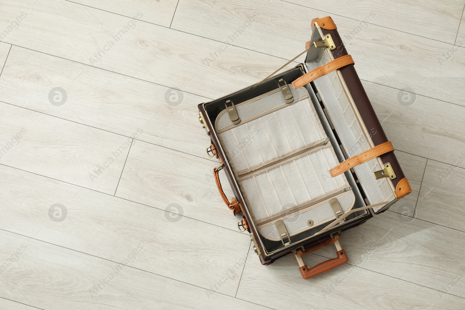 Photo of Open empty suitcase on floor indoors, top view. Space for text