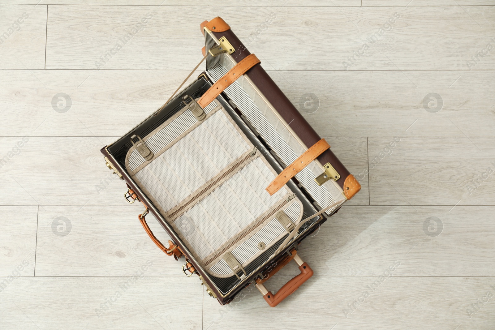 Photo of Open empty suitcase for travelling on floor indoors, top view