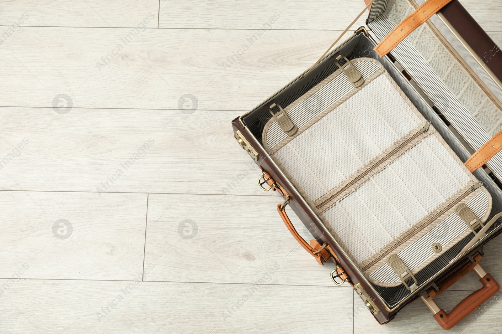 Photo of Open empty suitcase on floor indoors, top view. Space for text