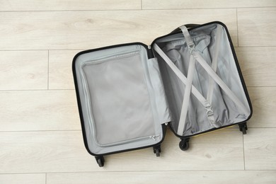 Photo of Open empty suitcase on floor indoors, top view. Space for text