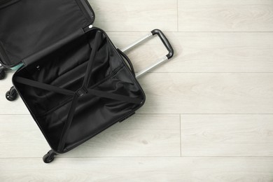 Photo of Open empty suitcase on floor indoors, top view. Space for text