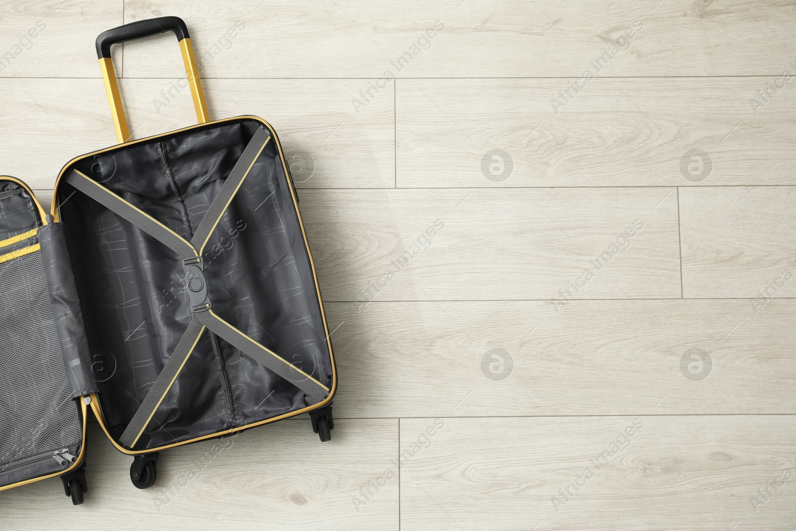 Photo of Open empty suitcase on floor indoors, top view. Space for text