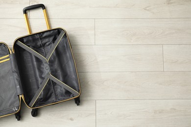 Photo of Open empty suitcase on floor indoors, top view. Space for text