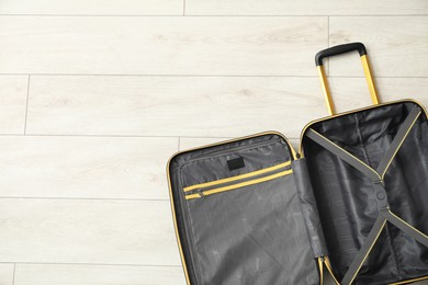 Photo of Open empty suitcase on floor indoors, top view. Space for text