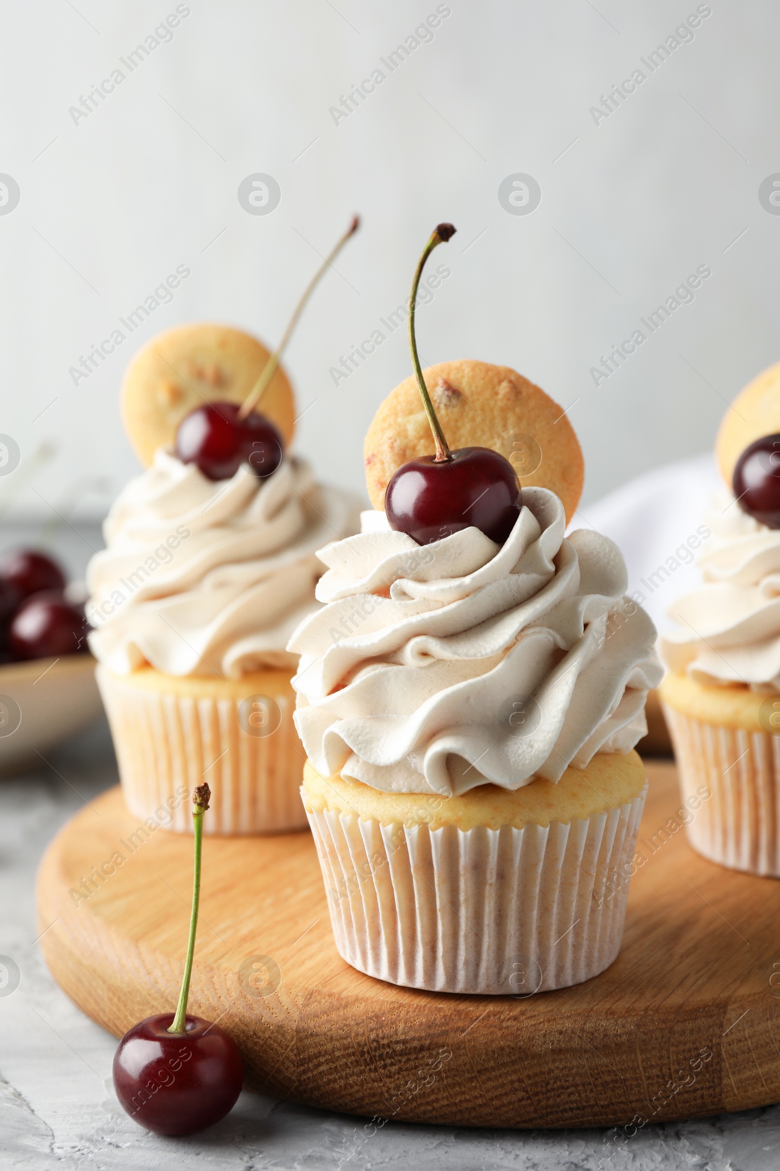 Photo of Delicious cupcakes with cherries and cookies on grey table, closeup