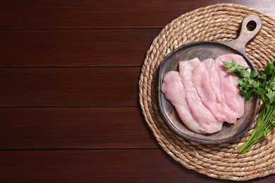 Photo of Making schnitzel. Board with raw meat and parsley on wooden table, top view. Space for text