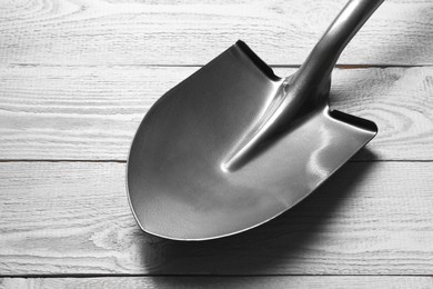 Photo of Metal shovel on light grey wooden table