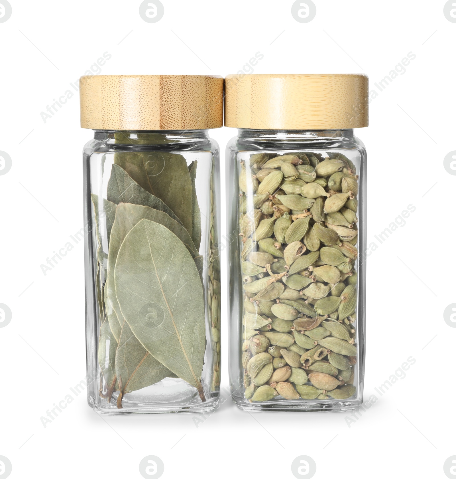 Photo of Bay leaves and cardamom in glass jars isolated on white