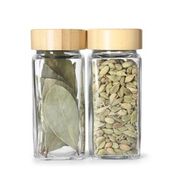 Photo of Bay leaves and cardamom in glass jars isolated on white