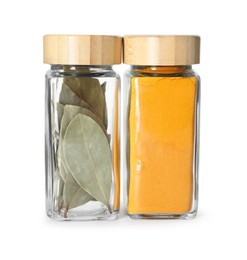 Bay leaves and curry powder in glass jars isolated on white