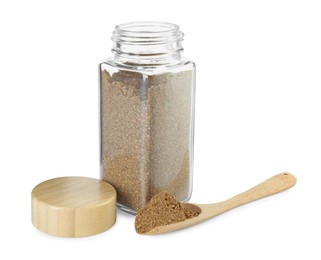 Photo of Cumin powder in glass jar and spoon isolated on white