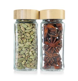 Cardamom and anise stars in glass jars isolated on white