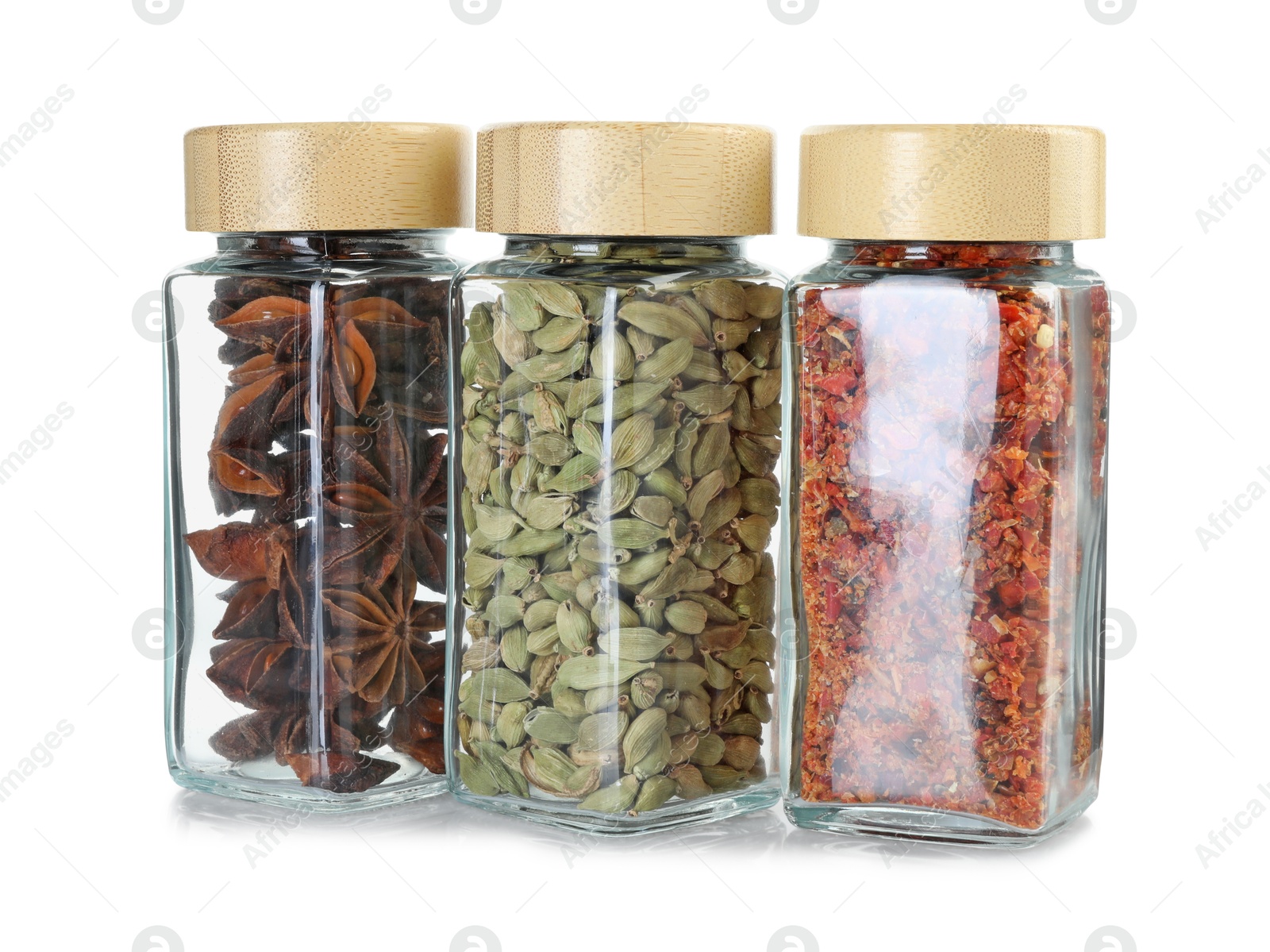 Photo of Different spices in glass jars isolated on white