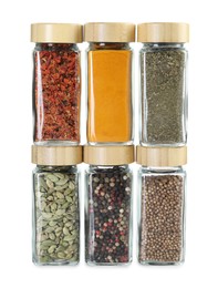 Photo of Different spices in glass jars isolated on white