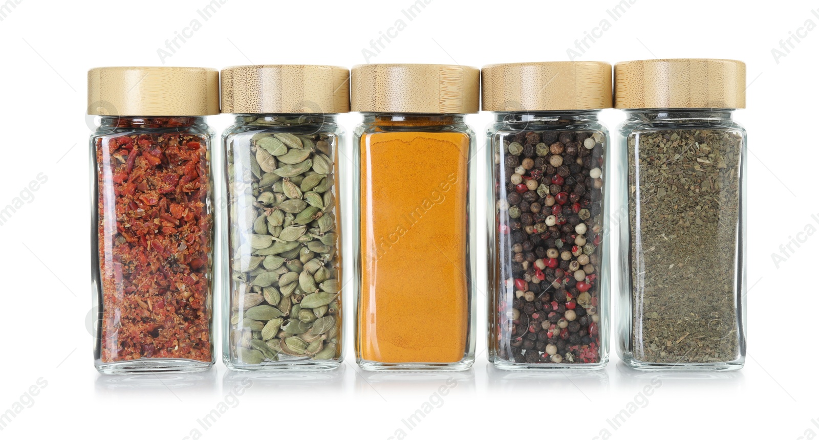 Photo of Different spices in glass jars isolated on white