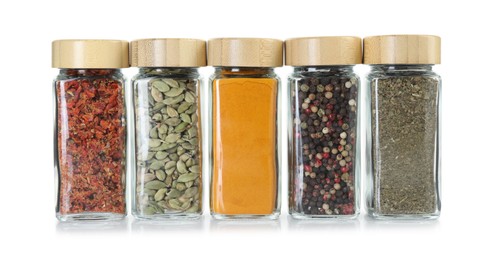 Photo of Different spices in glass jars isolated on white