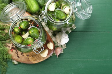 Photo of Making pickles. Fresh cucumbers and spices in jars on wooden table, flat lay. Space for text