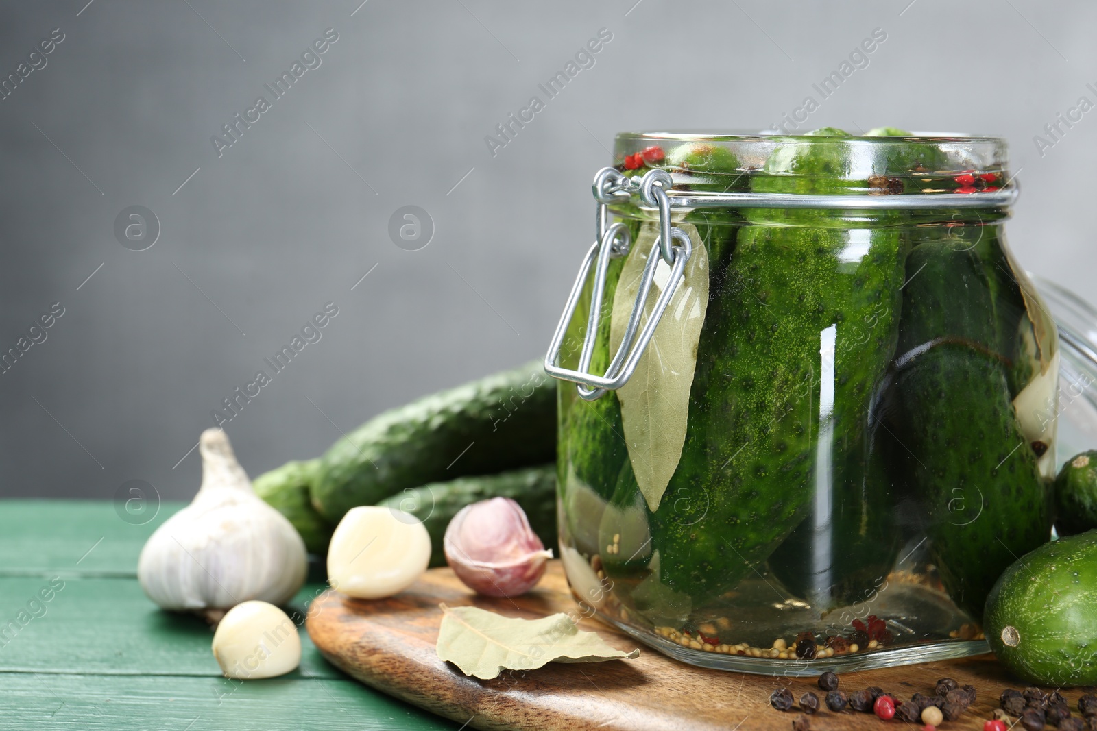 Photo of Making pickles. Fresh cucumbers and spices in jar on wooden table, closeup. Space for text