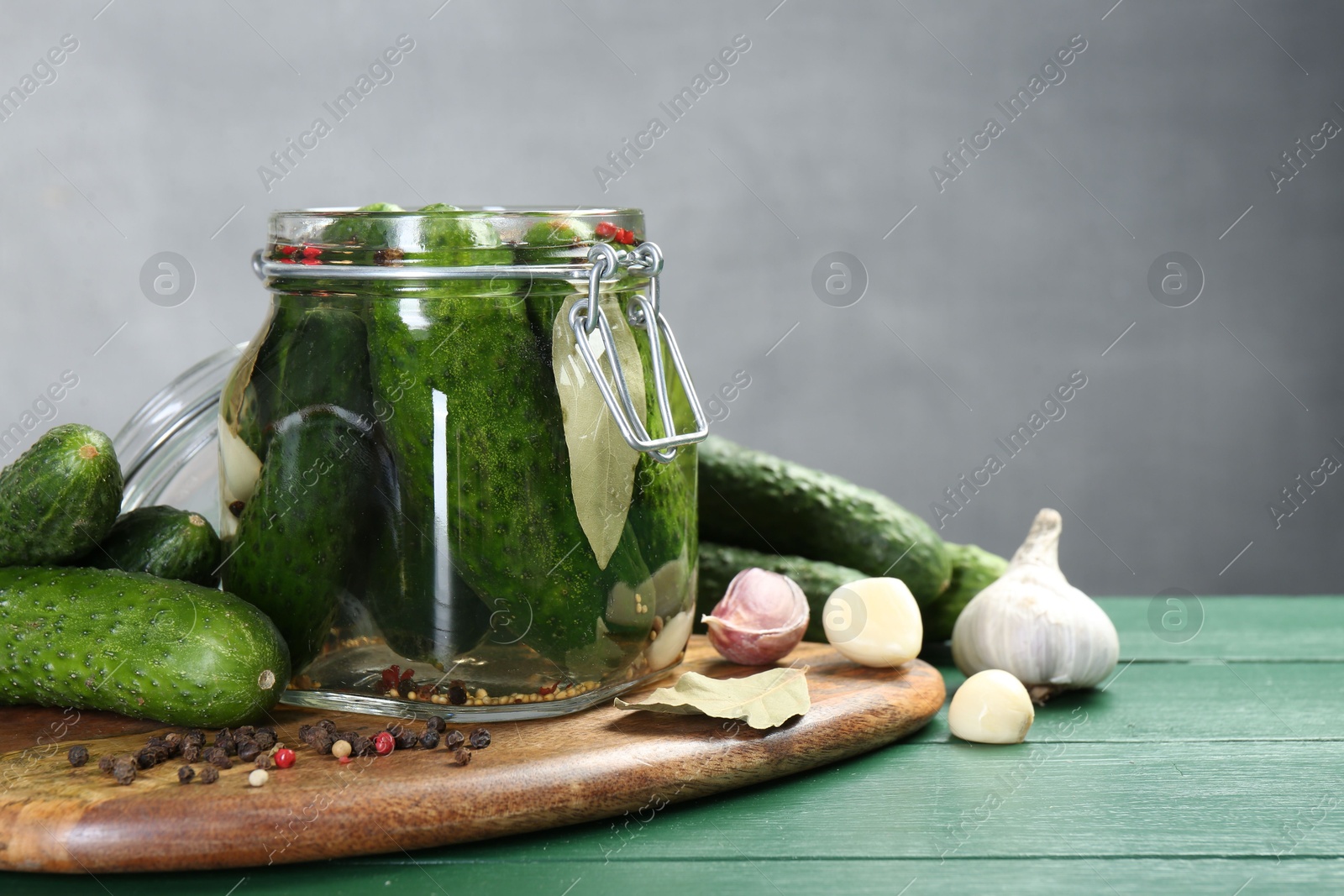 Photo of Making pickles. Fresh cucumbers and spices in jar on wooden table. Space for text