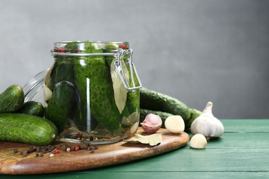 Photo of Making pickles. Fresh cucumbers and spices in jar on wooden table. Space for text