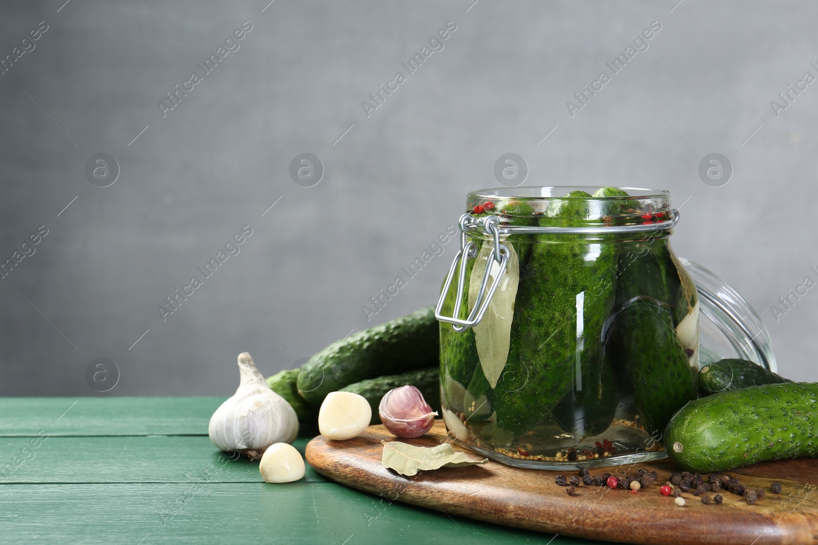 Photo of Making pickles. Fresh cucumbers and spices in jar on wooden table. Space for text